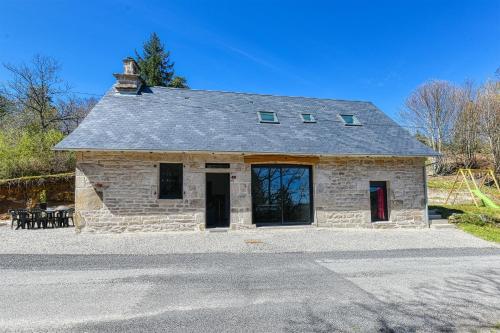 an old stone building with a red door at Gîte Theillac - Maison au calme avec beau jardin in Péret-Bel-Air