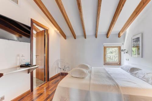 a bedroom with a large bed and a television at Desbrull in Pollença