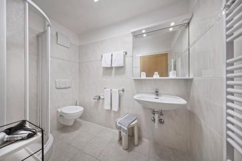 ティローロにあるGarni-Hotel Tritscherhofの白いバスルーム(洗面台、トイレ付)
