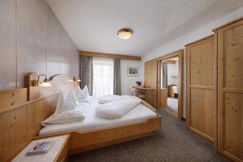 ティローロにあるGarni-Hotel Tritscherhofのベッドルーム1室(白いシーツと枕のベッド1台付)