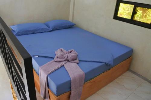 a bedroom with a bed with a bow on it at El Nido Lofts in El Nido
