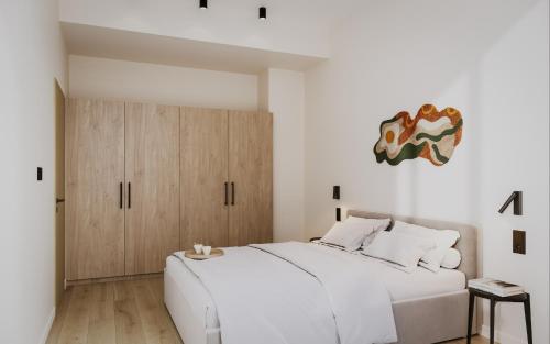 una camera con un grande letto bianco e armadi in legno di Bob W Kesklinn a Tallinn