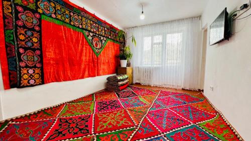 a room with a colorful rug on the wall at Dadow Cozy House in Naryn