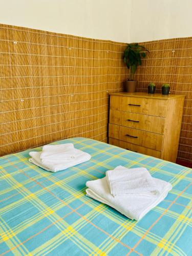 two white towels are sitting on a bed at DADOW Apartments in Naryn