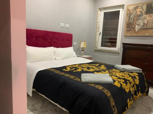 a bedroom with a large bed with a red headboard at bristol palace in Rodigo