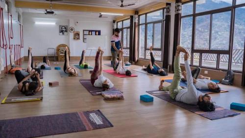 a group of people doing yoga in a room at Hotel Dream Catcher in Rishīkesh