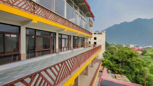 a balcony of a building with mountains in the background at Hotel Dream Catcher in Rishīkesh