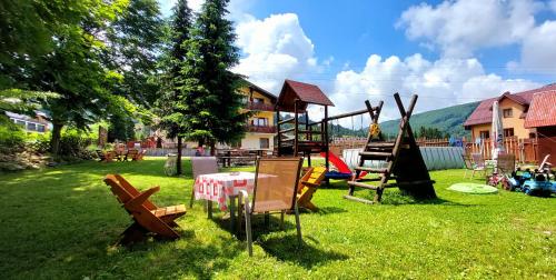 un parque infantil con mesa y sillas en el césped en Szymusiowa Szczyrk en Szczyrk