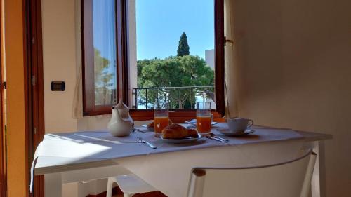 einen Tisch mit einem Teller Essen und einem Fenster in der Unterkunft B&B Agora' in Gardone Riviera