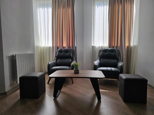 a living room with two chairs and a coffee table at Stay Inn Center in Tbilisi City