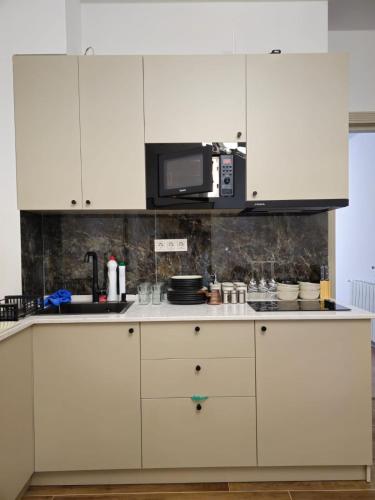 a kitchen with white cabinets and a microwave at Stay Inn Center in Tbilisi City