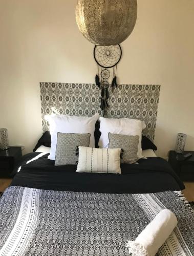 - une chambre avec un grand lit, des oreillers et une horloge dans l'établissement DREAM BEACH Room, à La Teste-de-Buch