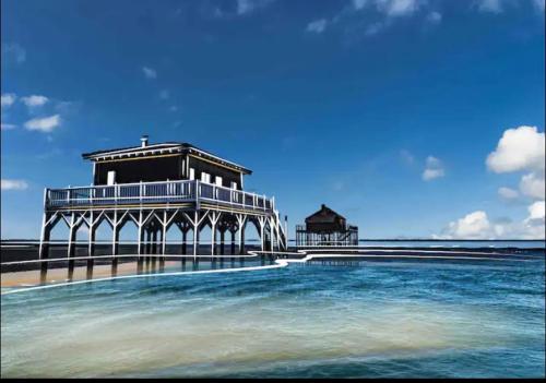 a pier with a building on the beach next to the water at DREAM BEACH Room in La Teste-de-Buch