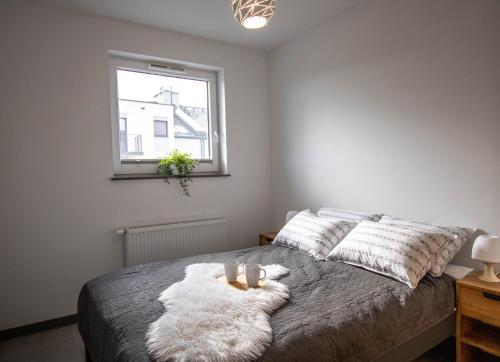 a bedroom with a bed with two candles on it at Apartamenty Milana Sztutowo in Sztutowo