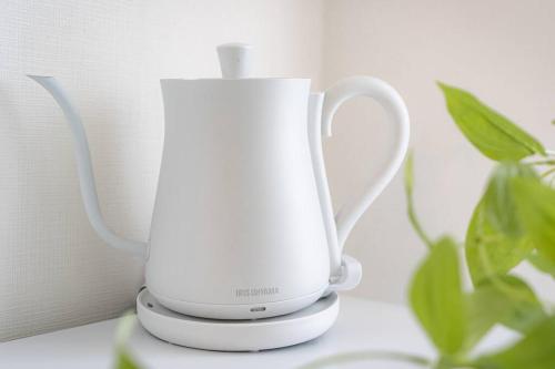 een witte blender op een toonbank naast een plant bij unito residence HIGASHISHINJUKU in Tokyo