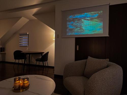a living room with a chair and a table at OUCHI HOTEL Hatchobori in Hiroshima