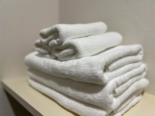 a stack of white towels sitting on a counter at OUCHI HOTEL Hatchobori in Hiroshima