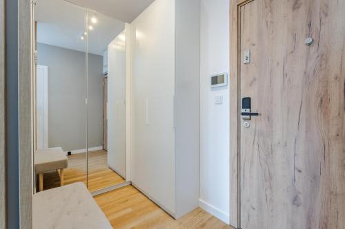 korytarz z drewnianymi drzwiami i pokojem w obiekcie Very Berry - Naramowicka 106A - Apartamenty z garażem i balkonem- self check in 24h w Poznaniu