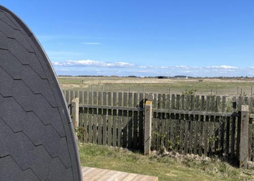 a surfboard sitting next to a wooden fence at Camping Vesterhav in Harboør