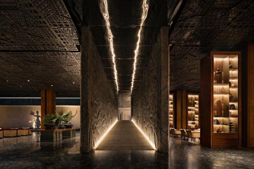 Cette chambre dispose d'un couloir avec des lumières sur le mur. dans l'établissement Bali Beach Hotel, à anur