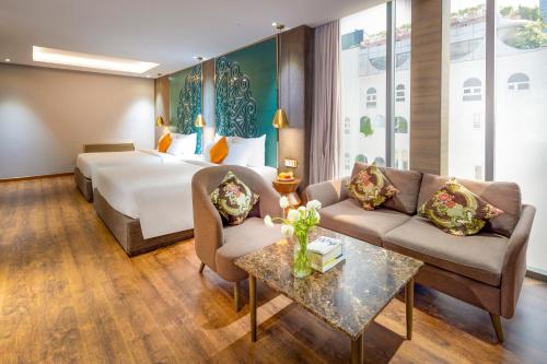 Habitación de hotel con cama y sofá en Winsuites Saigon - Luxury Boutique Hotel, en Ho Chi Minh