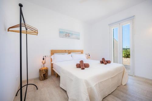 a white bedroom with two beds and a window at Son Crespi Vell 2 in Manacor
