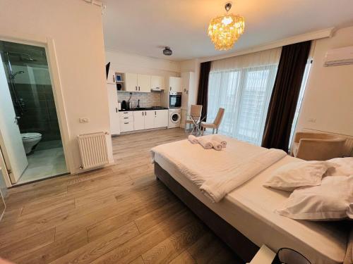 a bedroom with a large bed and a kitchen at The Chalet in Mamaia Sat/Năvodari