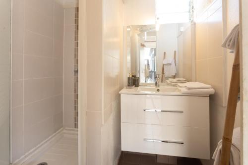 een witte badkamer met een wastafel en een douche bij 7 - LE VACOA - CHAMBRE 7 ETG g in Saint-Paul