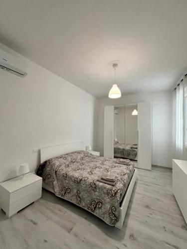 Habitación blanca con cama y espejo en Grey House, en Arezzo