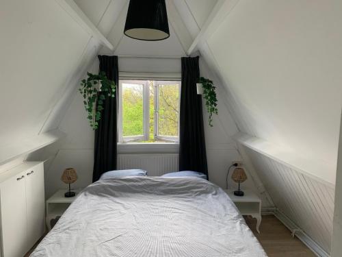 - une chambre avec un lit blanc et une fenêtre dans l'établissement Heerlijk vakantiehuis in bos bij Durbuy, à Durbuy
