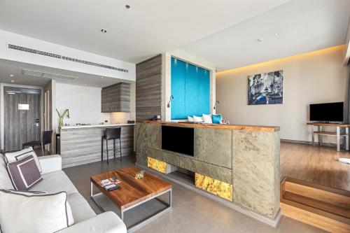 a living room with a fireplace and a kitchen at Cape Sienna Phuket Gourmet Hotel & Villas - SHA Extra Plus in Kamala Beach