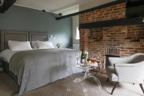 a bedroom with a bed and a brick wall at The Swan at Forest Row in Forest Row