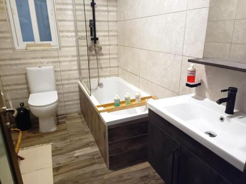 a bathroom with a tub and a toilet and a sink at Central 2BR Apartment with Balcony by Apricus Design in Msida