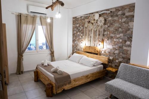 a bedroom with a bed and a chair in it at Onar Syros - Rustic Rooms in Ermoupoli