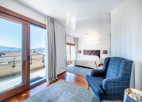 een slaapkamer met een bed en een groot raam bij Villa Vanessa in Lugano
