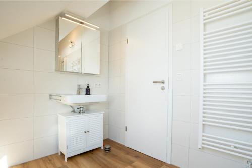 La salle de bains blanche est pourvue d'un lavabo et d'une douche. dans l'établissement IBM I Bertrandt I Küche I 6 Per., à Ehningen