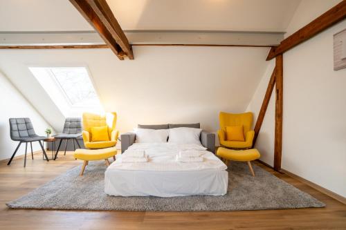 - une chambre avec un lit et deux chaises jaunes dans l'établissement IBM I Bertrandt I Küche I 6 Per., à Ehningen