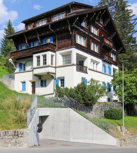 a large house with a wooden roof at Chalet Badrutt by Arosa Holiday in Arosa