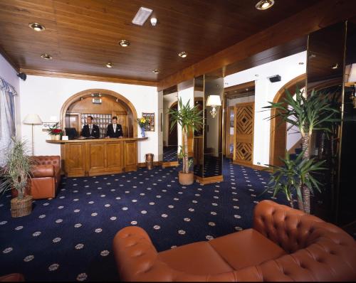 a lobby of a hotel with two men in the bar at Hotel Majoni in Cortina dʼAmpezzo