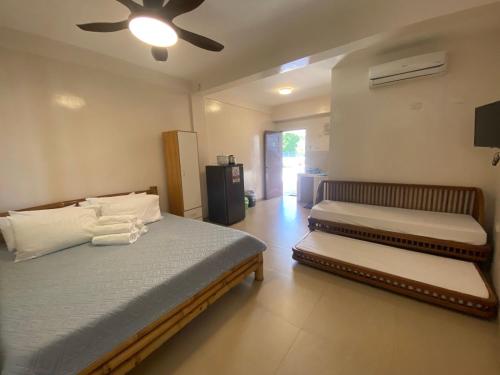 1 dormitorio con 2 camas y ventilador de techo en Villa Pamana Inn Puerto Galera powered by Cocotel, en Puerto Galera