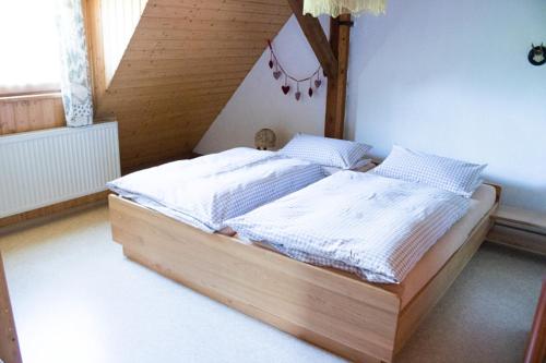 1 dormitorio con cama de madera en una habitación en Schwabenhof Ferienwohnung I, en Leutershausen