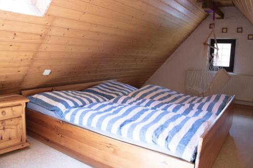 Cama en habitación con techo de madera en Schwabenhof Ferienwohnung I, en Leutershausen