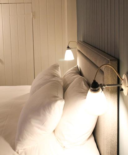 a bed with two white pillows and a lamp at The Swan at Forest Row in Forest Row