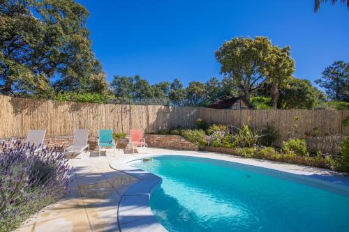 - une piscine dans un jardin avec des chaises et une clôture dans l'établissement Mon Petit Coin de Paradis, à La Londe-les-Maures