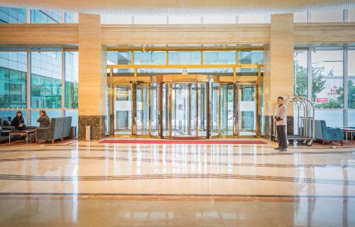 a man standing in the middle of a lobby at Novotel Ulaanbaatar in Ulaanbaatar