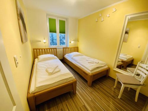 um pequeno quarto com 2 camas e um espelho em Charlotte, direkt am Kurpark em Warnemünde