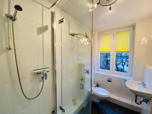 uma casa de banho com um chuveiro, um lavatório e um WC. em Charlotte, direkt am Kurpark em Warnemünde