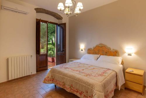 Un dormitorio con una cama y una ventana grande. en Golden View Apartment with pool, en Castiglioncello