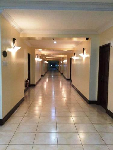 an empty hallway of a building with lights on the walls at Dottie's Place Hotel & Restaurant in Butuan