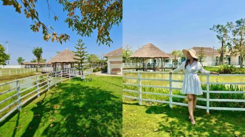 a woman in a white dress standing next to a fence at Private Villa in Phumĭ Prêk Chrey